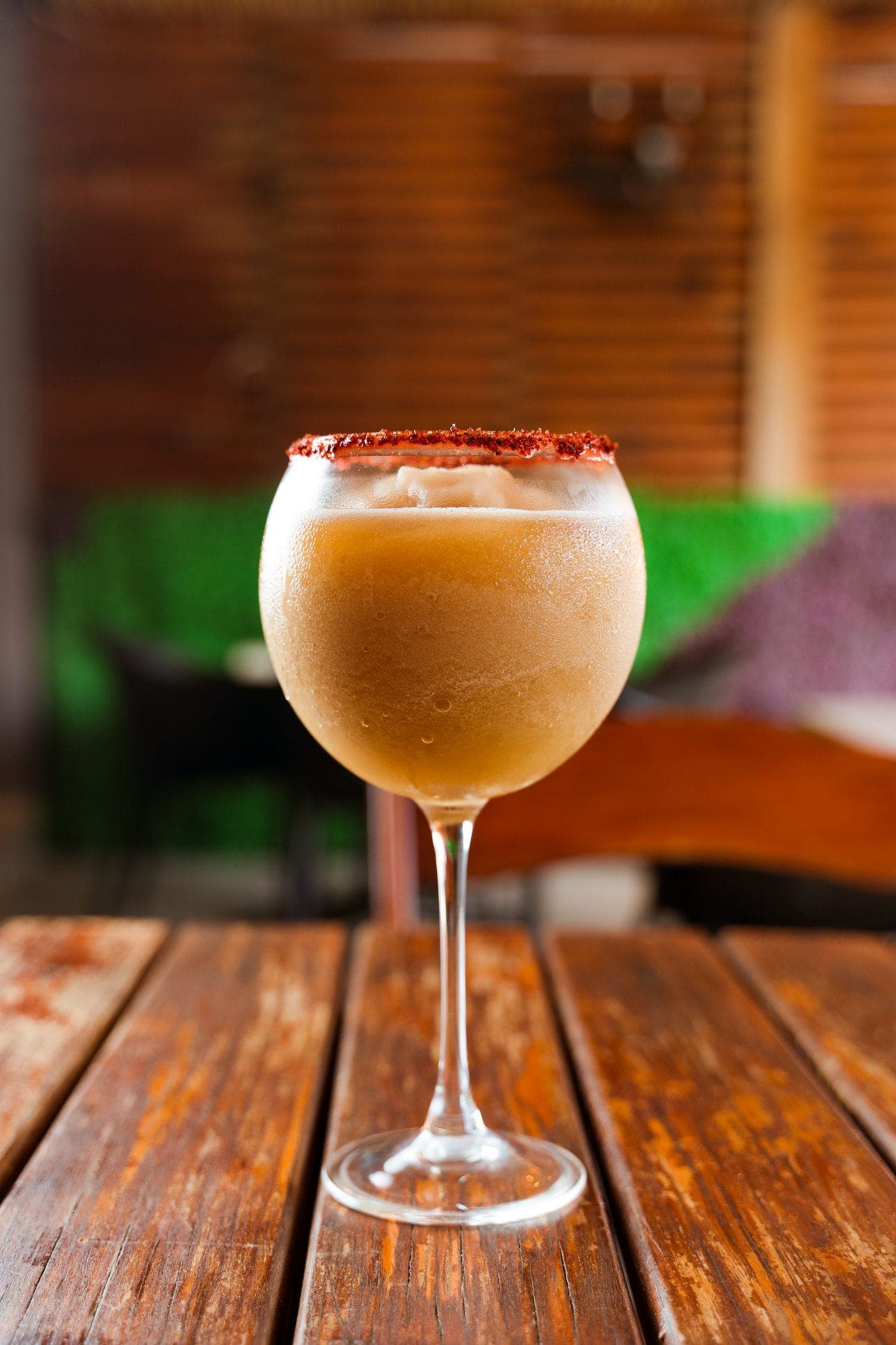 Coctel helado con escarchado de chile, sobre mesa de madera