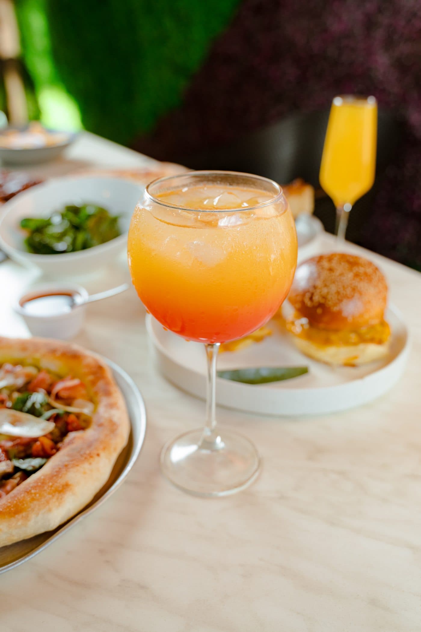 Mesa de Envy con pizza, hamburguesa y coctelería