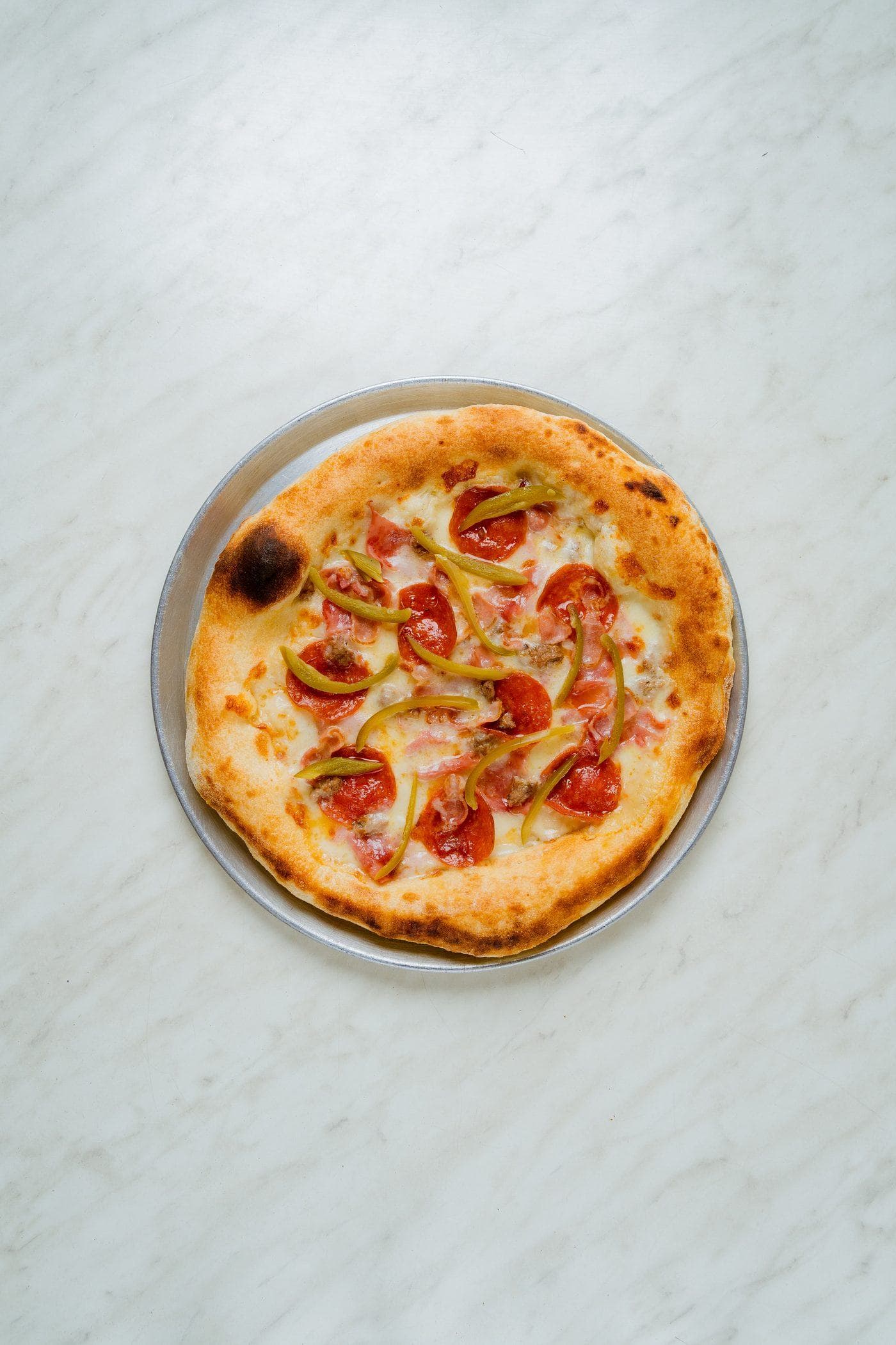 Pizza napolitana con orilla alta servida en charola